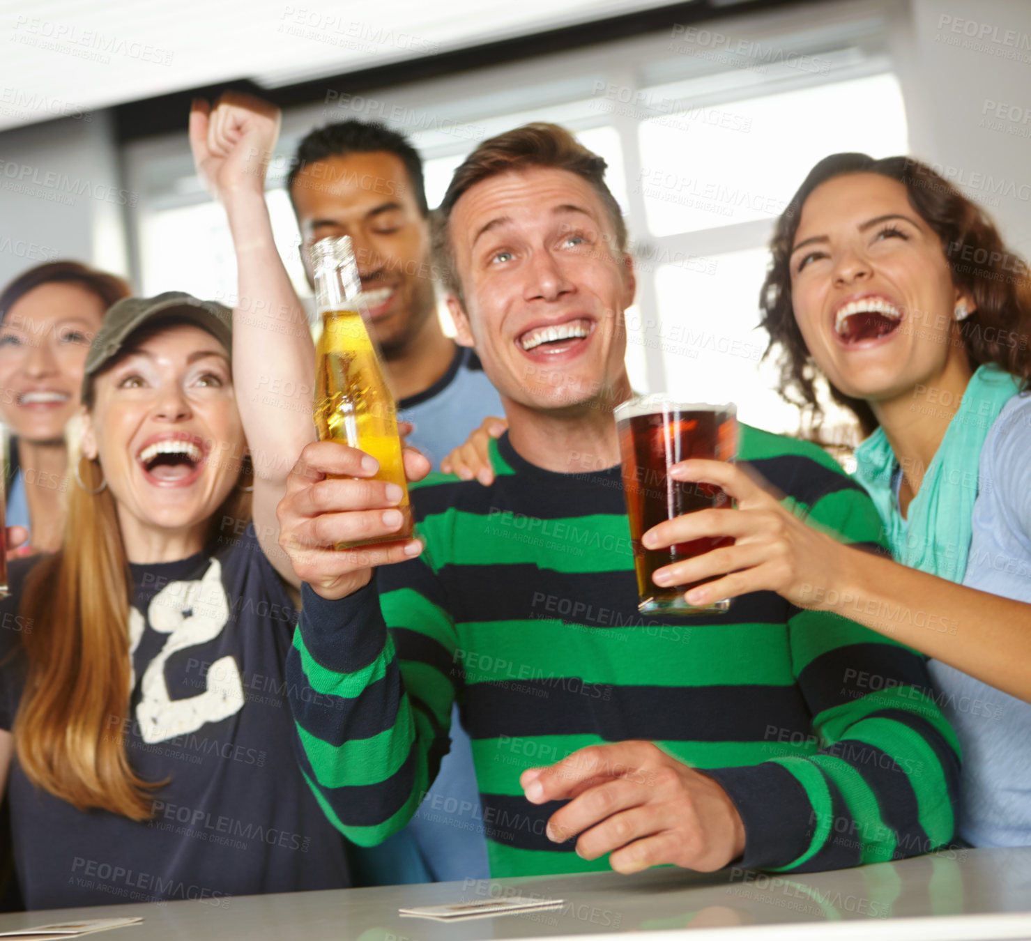 Buy stock photo A group of friends cheering on their favourite team at the bar