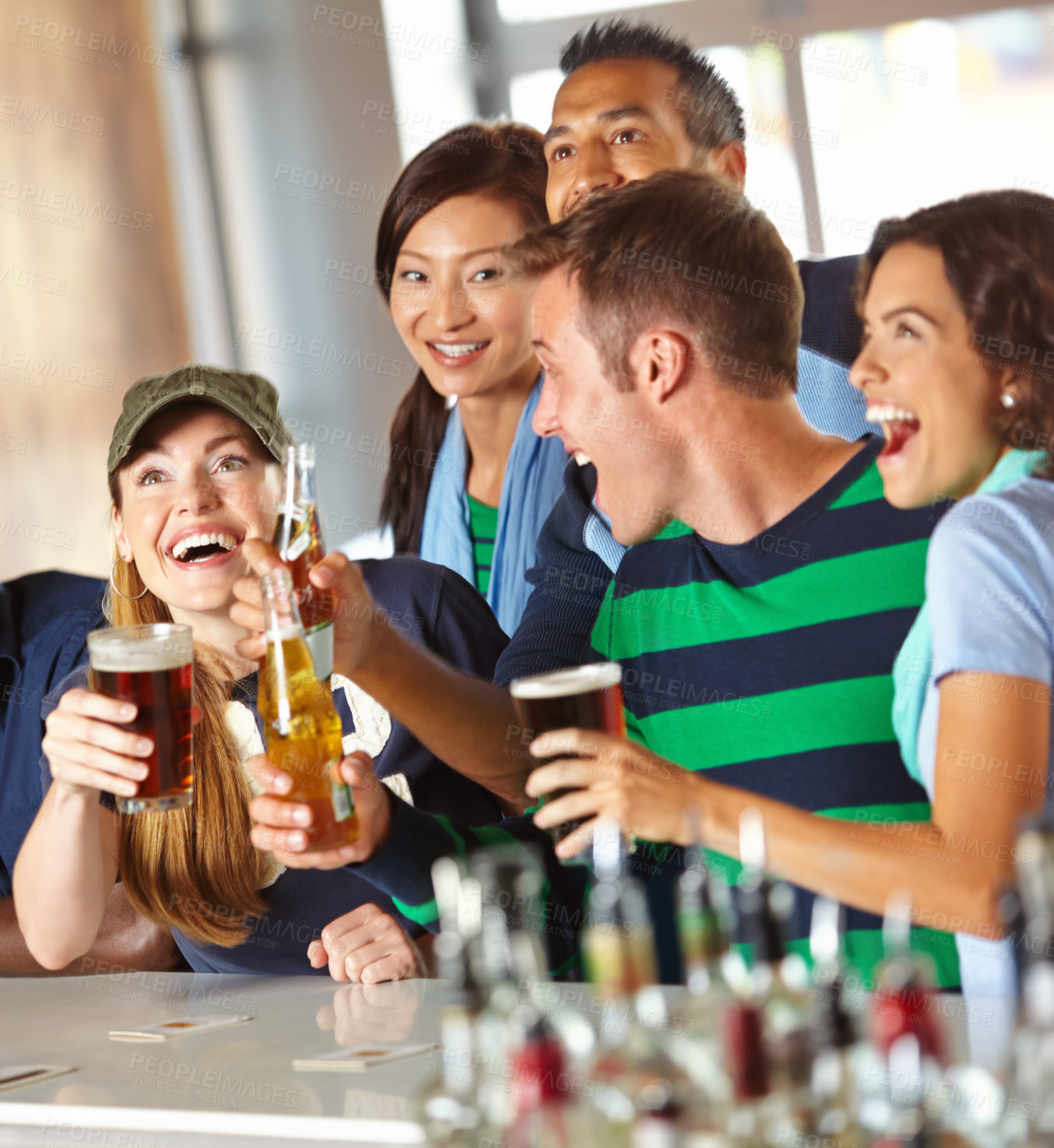 Buy stock photo A group of excited friends cheering on their favourite team at the bar