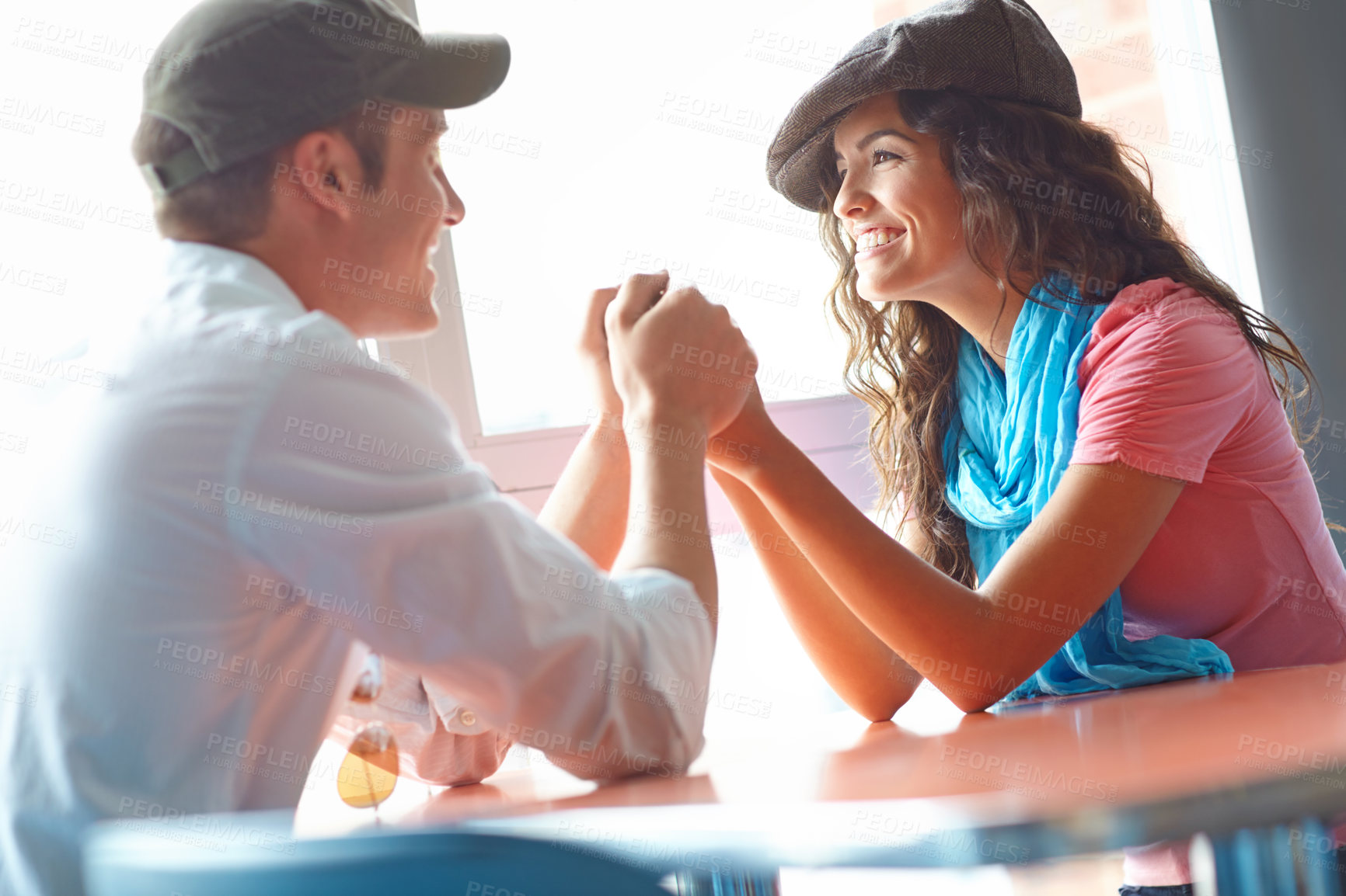 Buy stock photo A pretty young woman enjoying her boyfriends affections in a restaurant