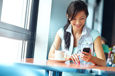 Buy stock photo Woman, phone and happy with texting at coffee shop, click and check notification in morning with drink. Asian person, smartphone and smile for mobile app with scroll, post and social media at cafe