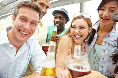 Buy stock photo Portrait of a young group of friends clinking their drinks together at a restaurant