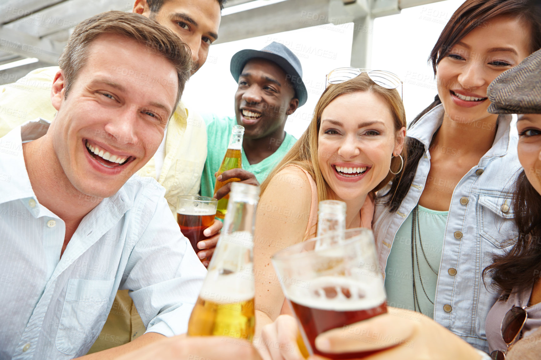 Buy stock photo Portrait of a young group of friends clinking their drinks together at a restaurant