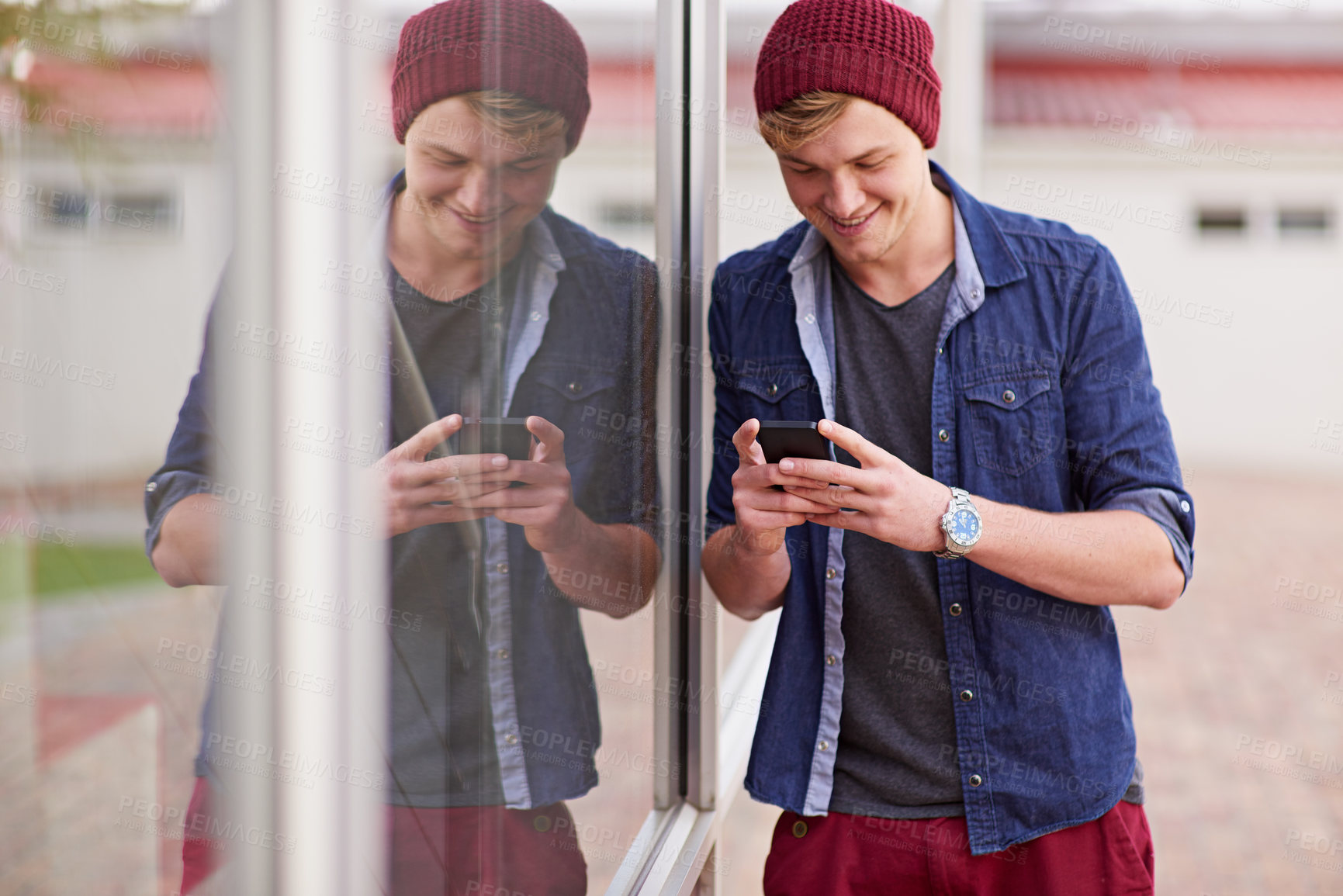 Buy stock photo Cellphone, smile and man in window reflection, texting and social media for student on campus. Technology, smartphone for communication for male learner, laugh and meme online for entertainment  
