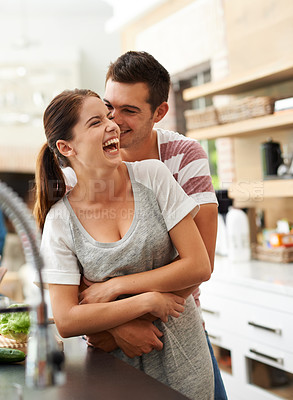 Buy stock photo Portrait of an attractive young couple bonding in the kitchen
