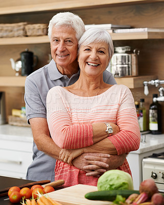 Buy stock photo Shot of an attractive senior couple posing affectionately in a kitchen 