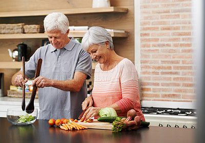 Buy stock photo Romantic shot of a senior couple cooking together indoors 
