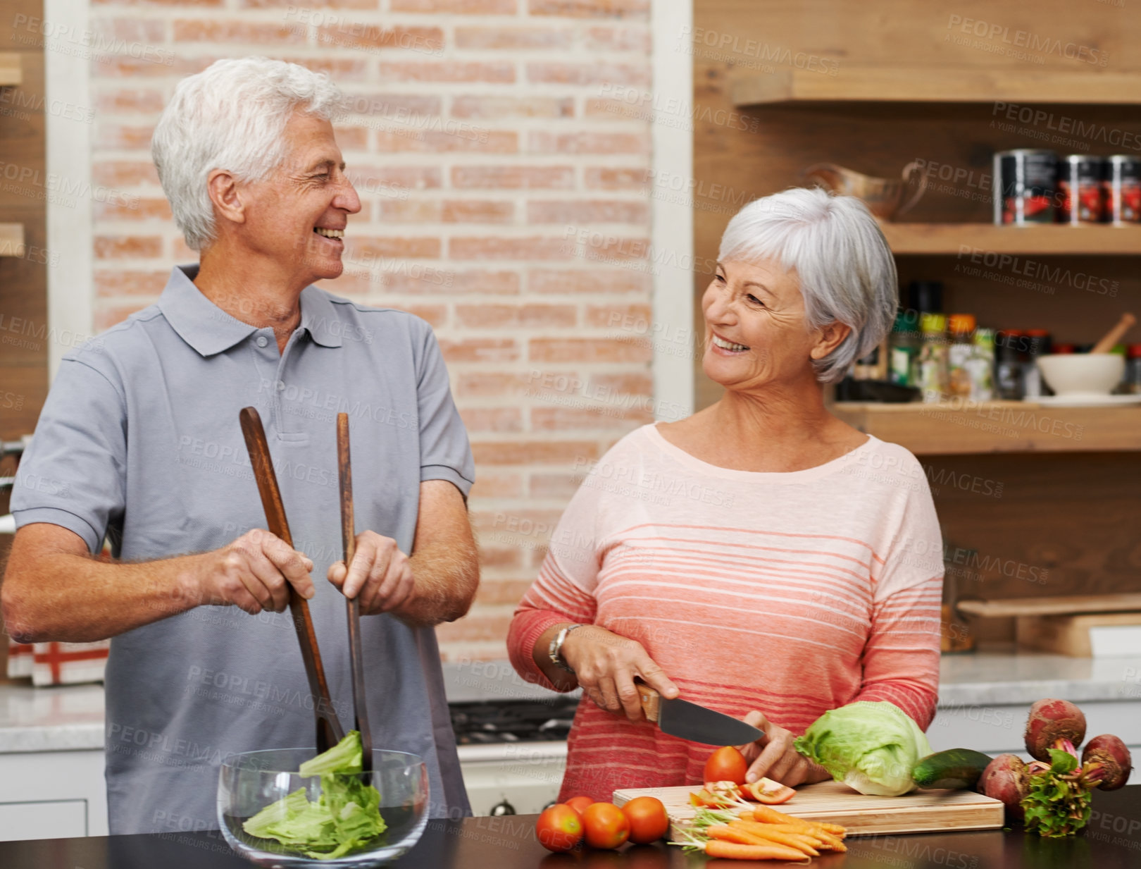 Buy stock photo Cooking, health and happy of old couple in kitchen for salad, love and nutrition. Helping, smile and retirement with senior man and woman cutting vegetables at home for food, dinner and recipe