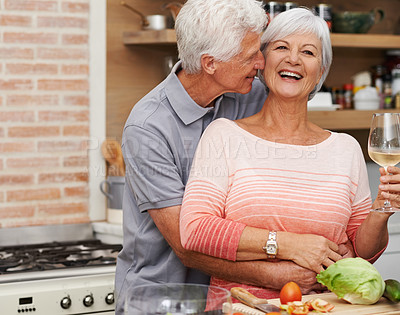 Buy stock photo Senior couple, hug and love in kitchen with wine for retirement, celebration and cooking in apartment. Old man, woman and vacation for happiness, commitment and wellness in modern house for holiday.