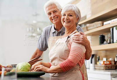 Buy stock photo Shot of a happy husband and wife in their kitchen