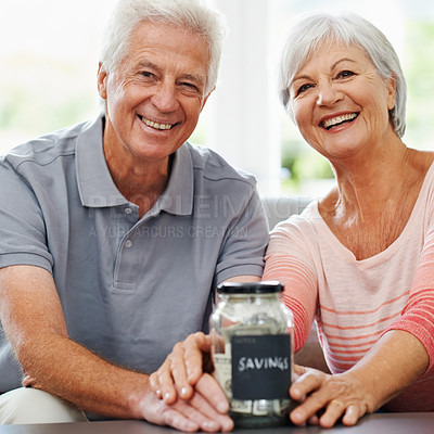 Buy stock photo Shot of a senior couple posing with their savings jar