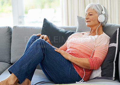 Buy stock photo Senior, woman and headphones on couch in house for relax, retirement and meditation, wellness and peace. Happiness, zen and podcast on couch in living room for self care, streaming and mindfulness