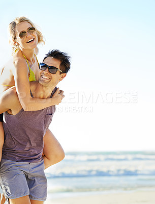 Buy stock photo Shot of a man carrying his girlfriend on the beach