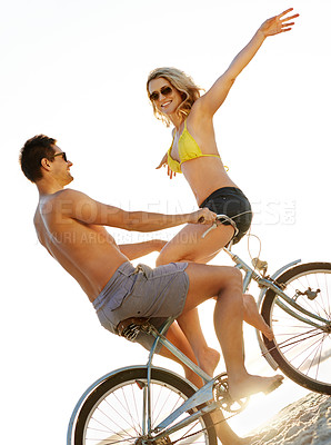 Buy stock photo Happy couple together at beach on bike in sunshine with arms, freedom or date with romance. Man, woman or vintage bicycle by ocean for bonding on fun vacation, balance in summer with topless people