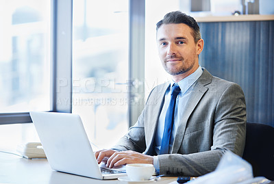 Buy stock photo Portrait of a smiling businessman working on a laptop in the office