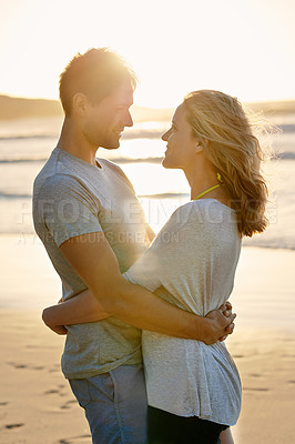 Buy stock photo Lens flare, sunset and hug of couple at beach, ocean and sea with affection, bonding and love in summer. People, partners and romance for care together on vacation, holiday and travel in Australia