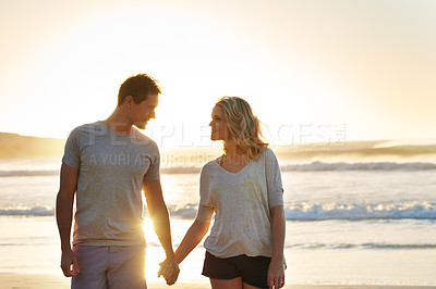 Buy stock photo Holding hands, sunset and couple with love at beach, ocean and sea for affection, bonding or to relax. People, partners and romance for care together on vacation, holiday and travel in Australia