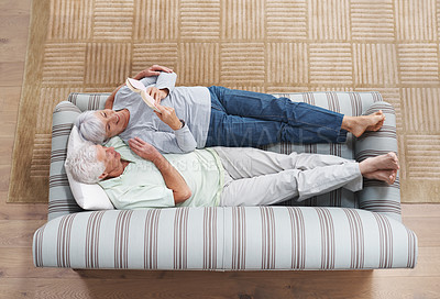 Buy stock photo A senior couple lying on a couch together