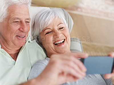 Buy stock photo Happy senior couple, selfie and relax on sofa in living room with smile for photo, memory or profile picture at home. Elderly man and woman smiling for photograph, vlog or social media on couch
