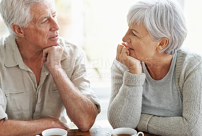 Buy stock photo Senior couple, talking and drinking tea in home for conversation, communication and quality time together. Old man, elderly woman and chat with cup of coffee for break, retirement and romantic love