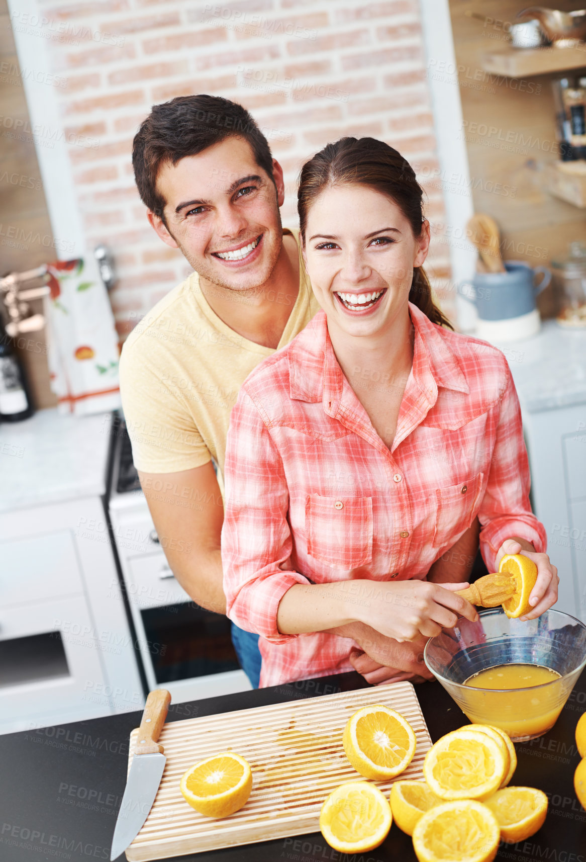 Buy stock photo Couple, kitchen and smile with orange for juice in bowl for health, nutrition and diet with ingredients. Home, relationship and bonding with fruit for sweet flavor, lunch snack and fresh  in portrait