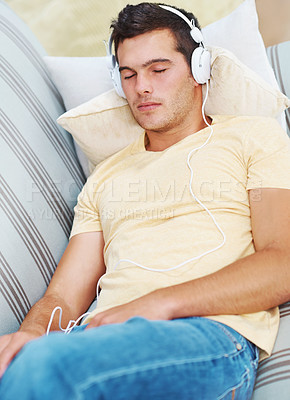 Buy stock photo Man, sleeping and music on couch, headphones and rest in living room, relax and live stream. Exhausted, peace and sofa at home for falling asleep, calm and tired or listening to podcast for zen