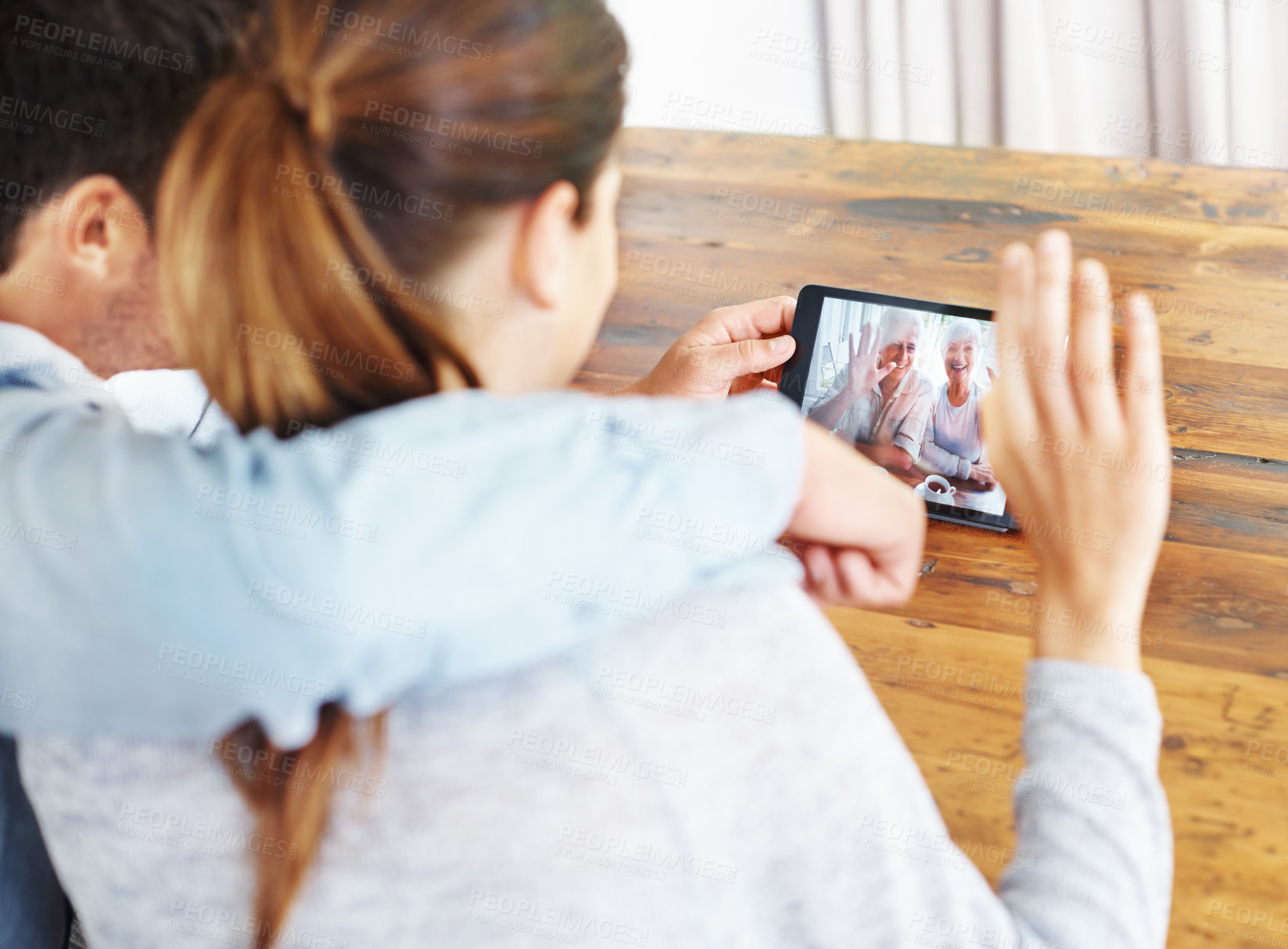 Buy stock photo Couple, tablet and video call with grandparents for online conversation or greeting at home. Rear view of man and woman talking or waving with technology for virtual meeting, talk or communication