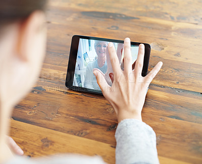 Buy stock photo A young woman using a digital tablet for a video call with her family