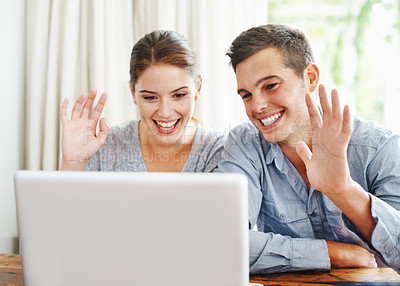 Buy stock photo Video call, home and couple with greeting, laptop and connection with internet, communication and webinar. Apartment, relax and man with woman, online gathering and virtual meeting with hand gesture