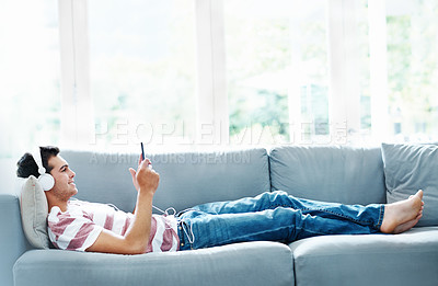 Buy stock photo Man, headphones and phone on sofa in house for music, streaming and self care while on study break. Guy, headset and tech on couch in home living room for social media, video and app or radio