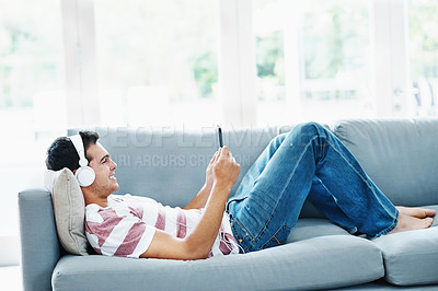 Buy stock photo Male person, headphones and phone on sofa in house for music, streaming and self care while on study break. Man, headset and tech on couch in home living room for social media, video and app or radio