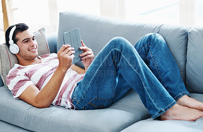 Buy stock photo Smile, headphones and man with tablet on sofa for online streaming, video and watching movie. Happy, relax and male person with technology at home for network, connectivity or subscription on weekend