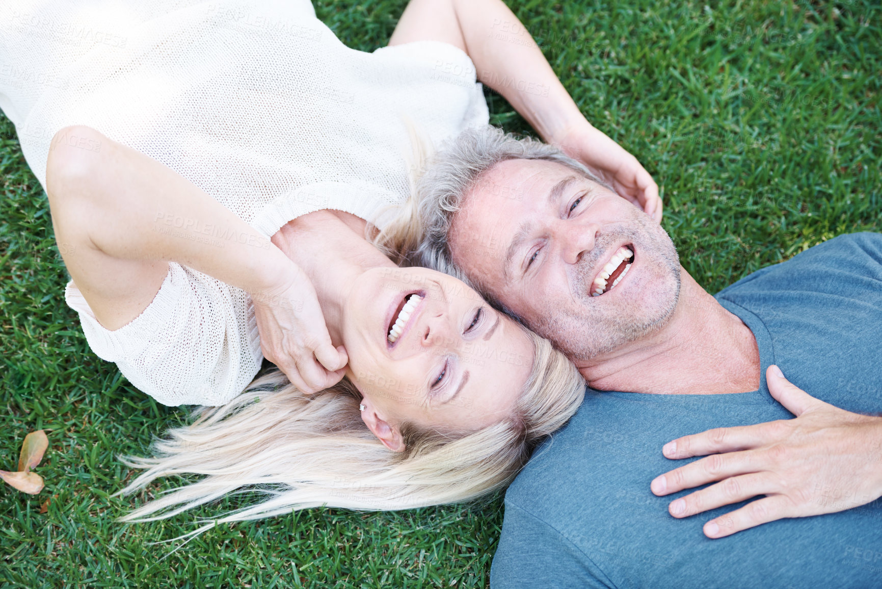 Buy stock photo Man, woman and mature or laughing in nature on grass field for funny joke or comedy, connection or top view. Happy couple, relax and backyard in Australia for relationship bonding, park or marriage