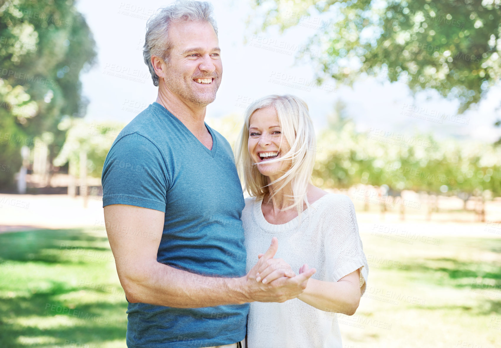 Buy stock photo Happy, holding hands and mature couple in park for bonding, relationship and commitment on weekend. Love, retirement and senior man and woman embrace for romance, relaxing and marriage in nature