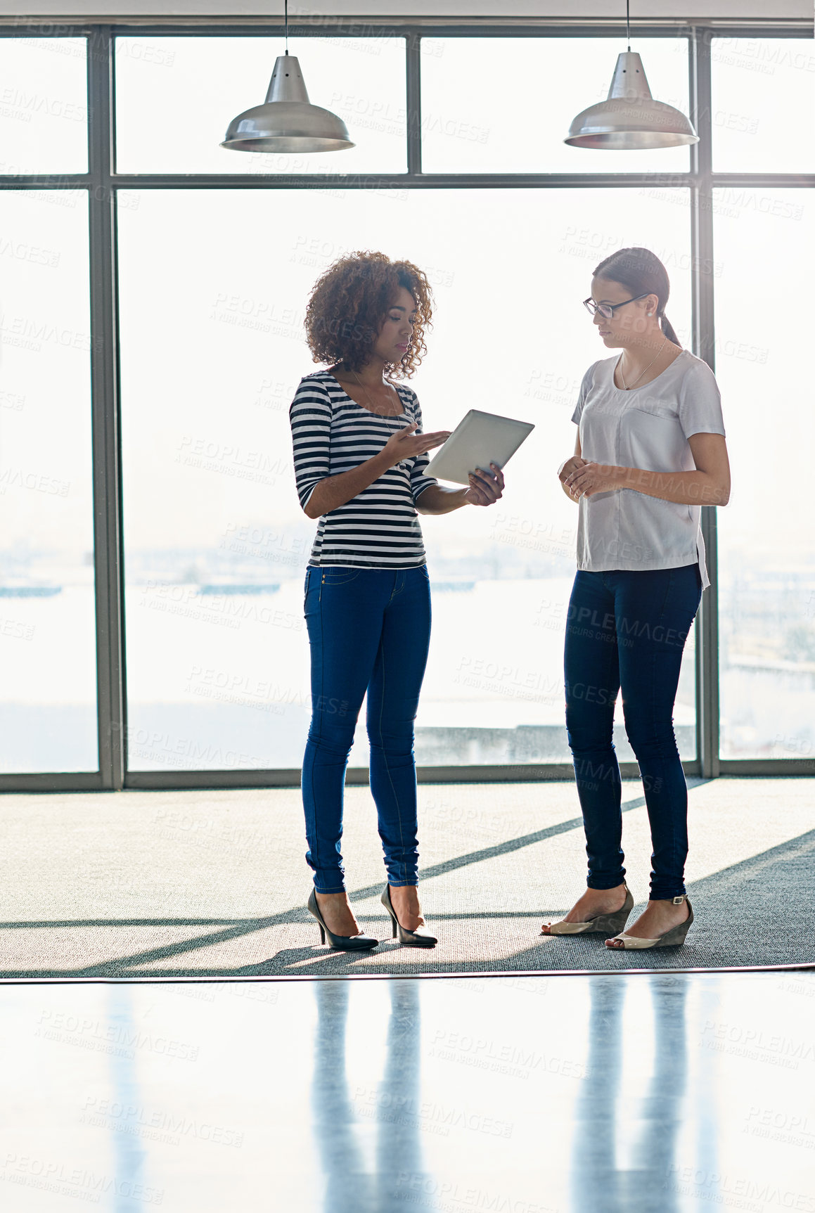 Buy stock photo Creative woman, colleagues and discussion with tablet by window for project, research or deadline at office. Female person, designers or employees talking with technology for ideas, web or startup