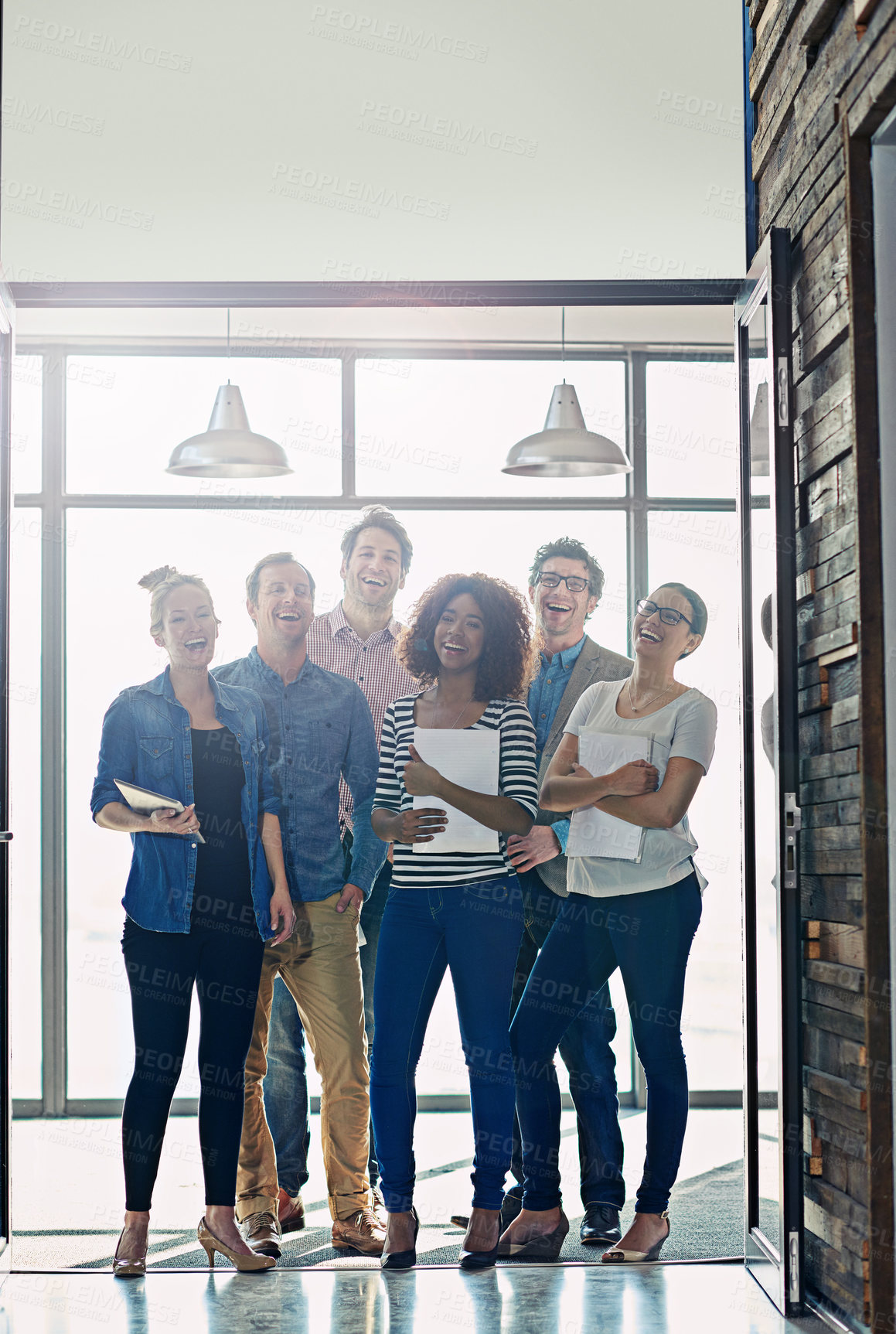 Buy stock photo Portrait of a group of positve-looking coworkers standing in front of a window in an office