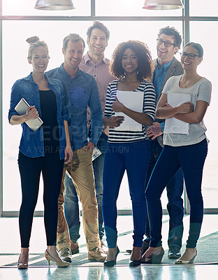 Buy stock photo Portrait of a group of positve-looking coworkers standing in front of a window in an office