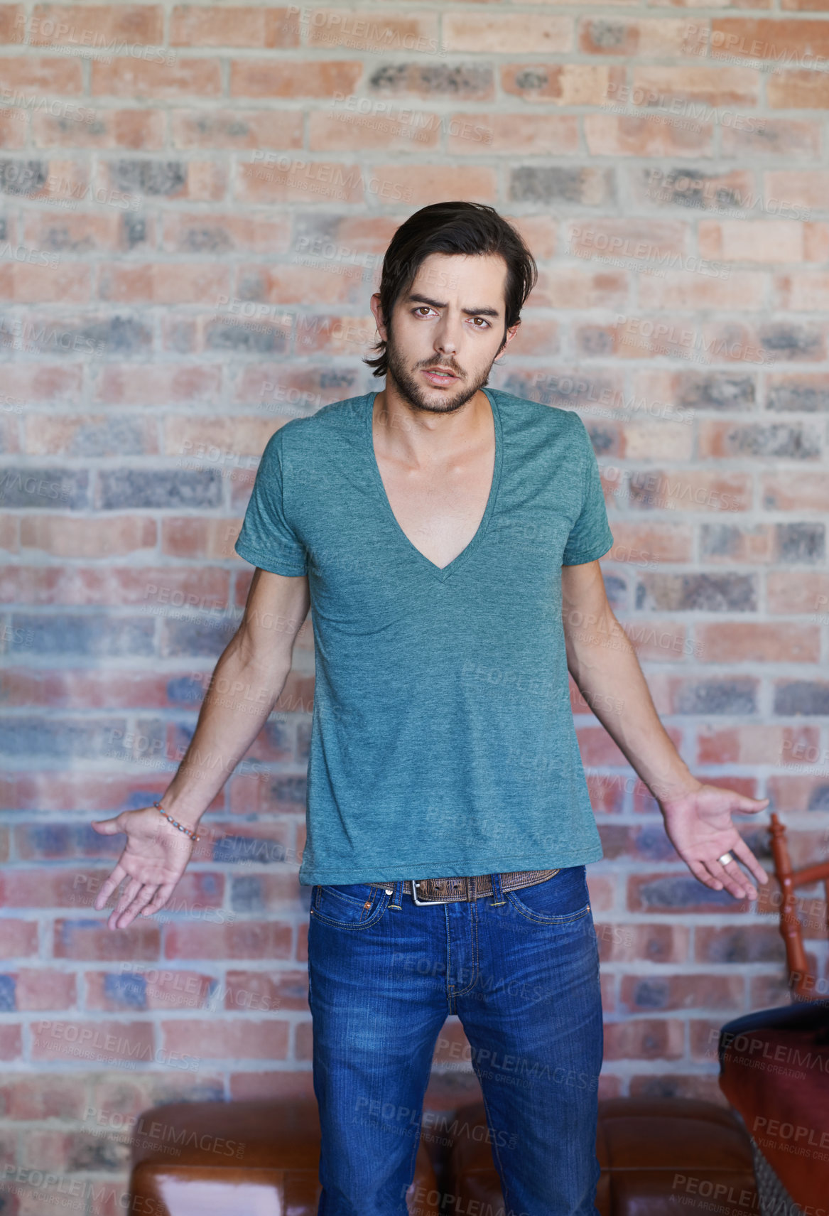 Buy stock photo Man, portrait and question gesture by brick wall confused with doubt and tshirt for style in Germany. Male person, asking why and clueless model in trendy fashion for body language or risky decision