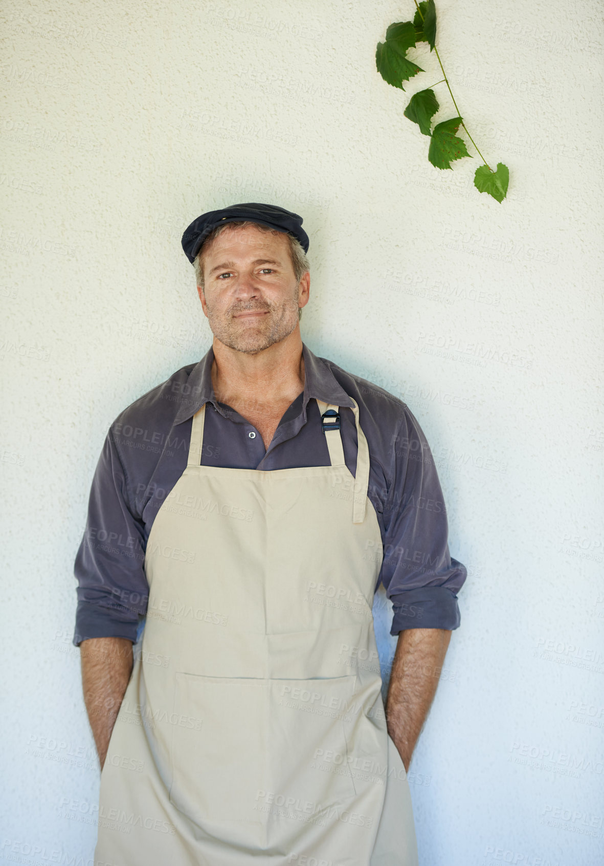 Buy stock photo A farmer in an apron standing in front of a wall 