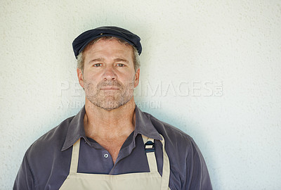 Buy stock photo A farmer in an apron standing in front of a wall 