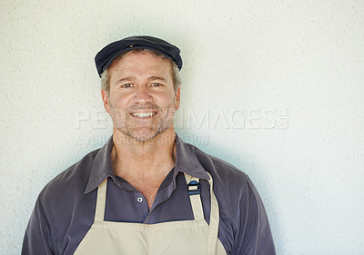 Buy stock photo A farmer in an apron standing in front of a wall 