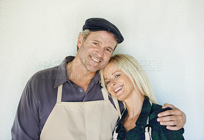 Buy stock photo Studio, portrait and couple with apron, hug and partnership in small business, growth and market. White background, man and woman with happiness for industry, owner and entrepreneur and career