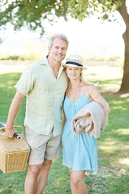 Buy stock photo A happy couple standing outside with a picnic basket and a blanket