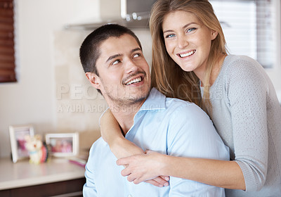 Buy stock photo A smiling affectionate couple sitting in the kitchen