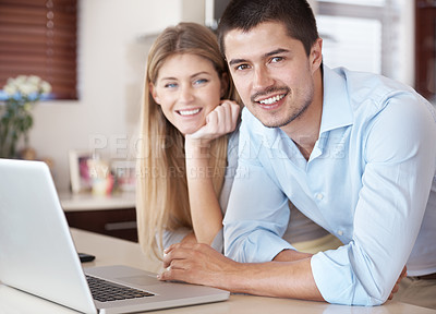 Buy stock photo Portrait of a smiling couple in their kitchen with a laptop in front of them