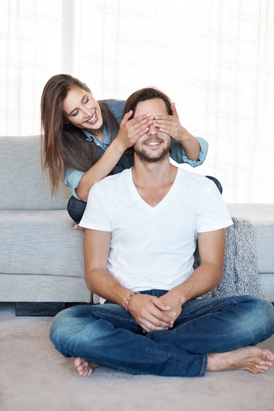 Buy stock photo Couple, living room and marriage with surprise on couch, smile and fun in new home. Love, wife covering eyes of husband and in modern apartment, trust and happy or together on sofa at family house