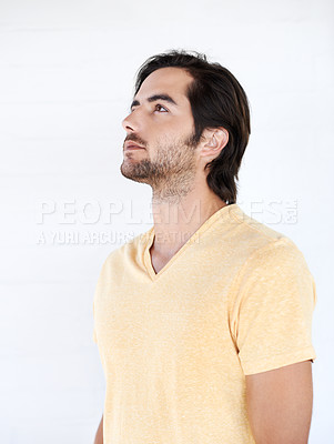 Buy stock photo Casual, thinking and man looking up in a studio while being thoughtful or wondering for an idea. Pensive, daydreaming and young male model from Canada with stylish tshirt isolated by white background