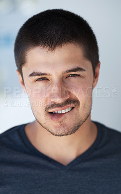 Buy stock photo Handsome young man biting his lip with a smile