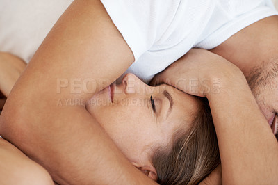 Buy stock photo Attractive young man embracing his partner while they lie in bed together