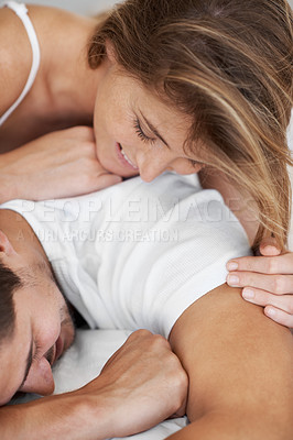 Buy stock photo Playful young couple lying in bed together