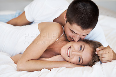 Buy stock photo Attractive young woman smiling as her partner leans in to kiss her